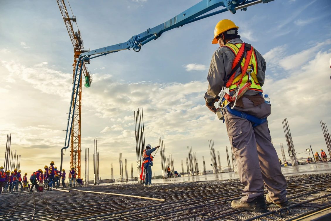 Equipe de obra acompanhando concretagem de laje com armação exposta